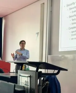 Referent hält die Gastvorlesung zu 5G Security an der Goethe-Universität Frankfurt, daneben die Projektionsfläche