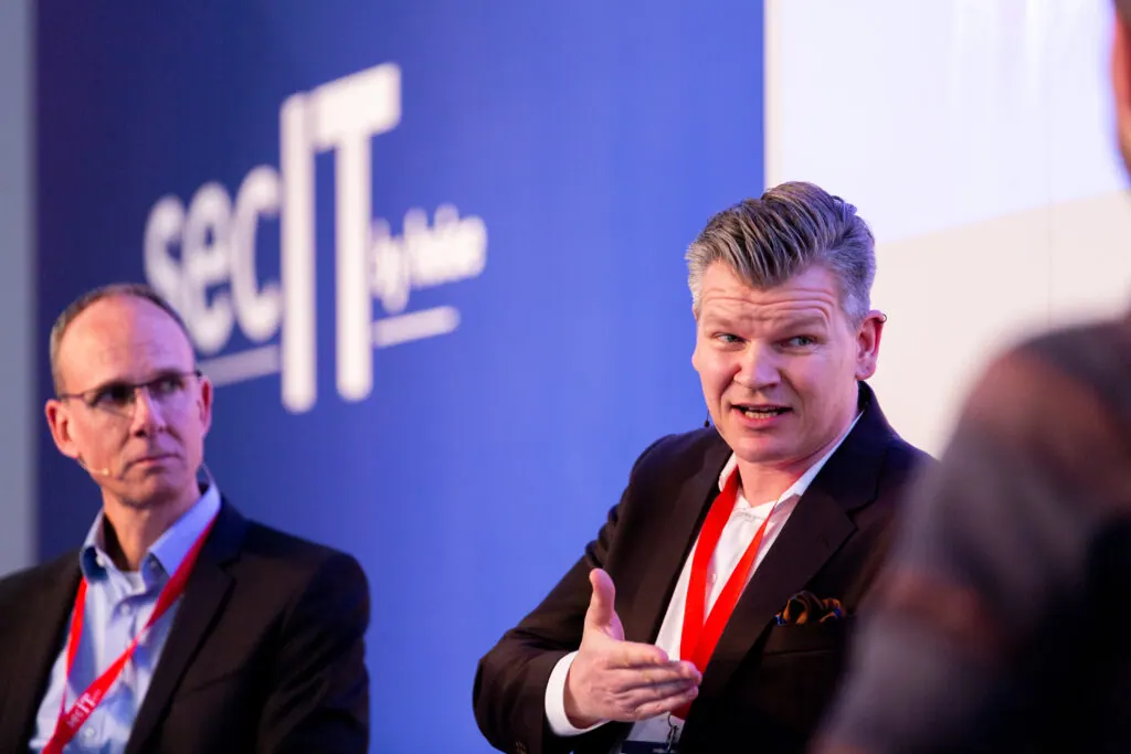 Podiumsdiskussion auf der secIT by heise 2024, ein Vertreter von secuvera spricht, links daneben ein weiterer Teilnehmer