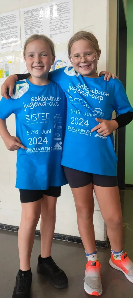 Zwei Kinder in blauen Trikots des Schönbuch Jugend-Cups, auf denen auch das secuvera-Logo als Sponsor steht