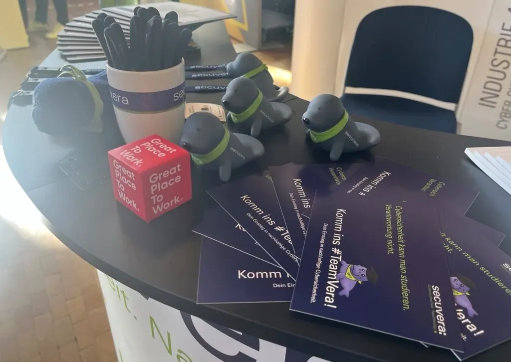 Standtisch mit Vera-Seekühe, Karriere-Postkarten „Komm ins #TeamVera“ und Great-Place-to-Work-Würfel