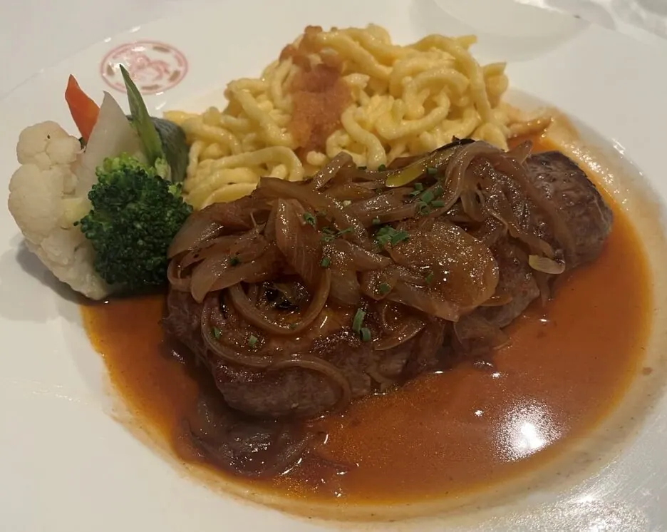 Hauptgericht mit Fleisch, Zwiebelsauce, Spätzle und Gemüse beim Abendessen des Jahresmeetings 2025