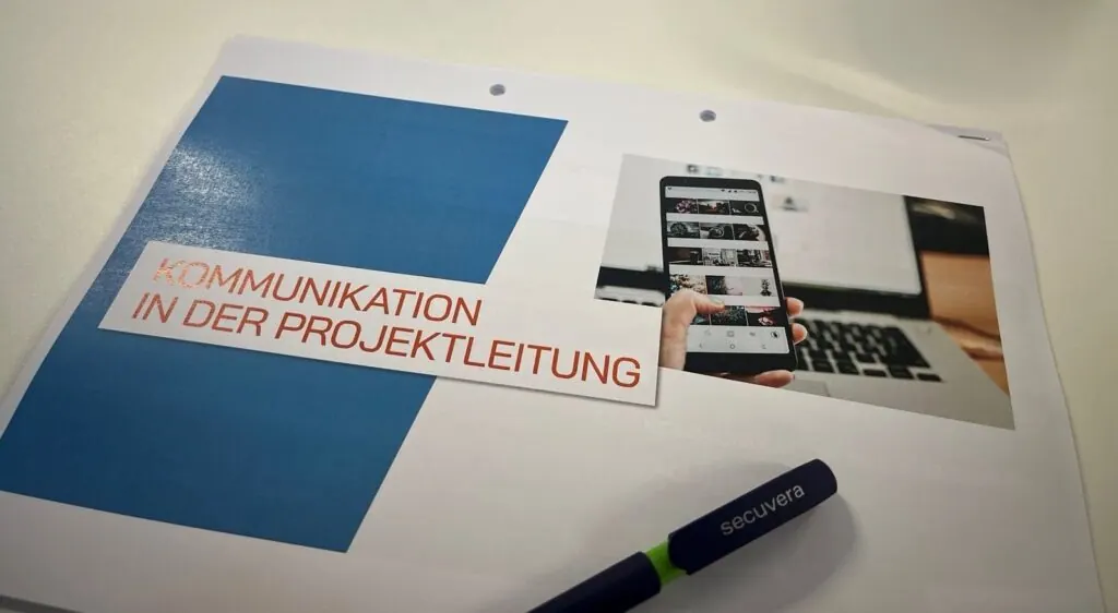 Schulungsunterlage „Kommunikation in der Projektleitung“ mit secuvera-Stift beim Kommunikationstraining 2025