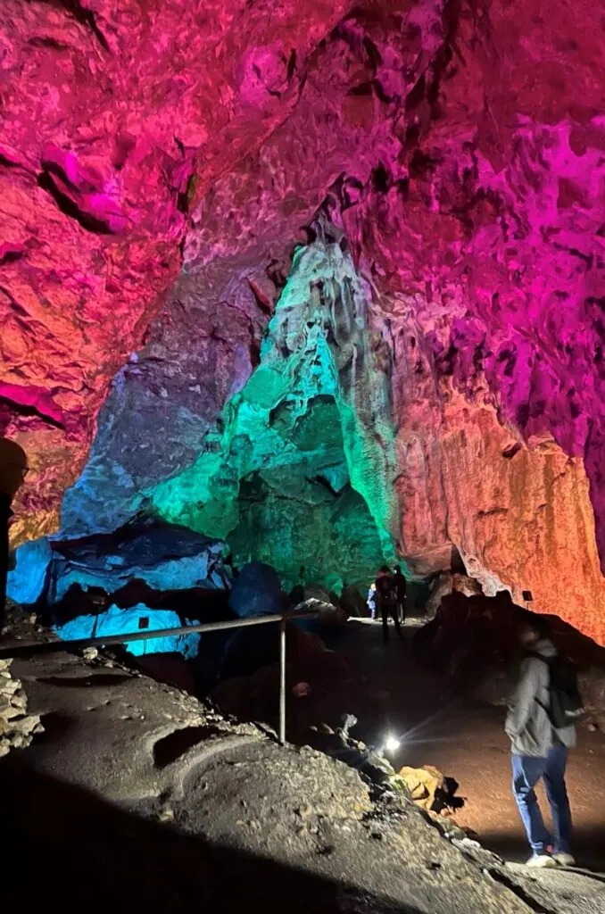 Bunt beleuchtete Tropfsteinhöhle mit Besuchern beim Betriebsausflug 2025