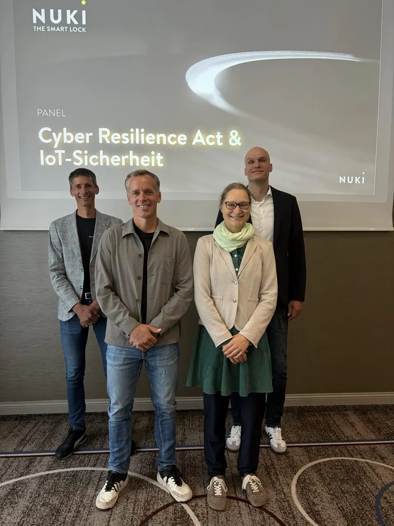 Vier Teilnehmende des Panels „Cyber Resilience Act & IoT-Sicherheit“ vor einer Projektionsfläche mit Nuki-Logo