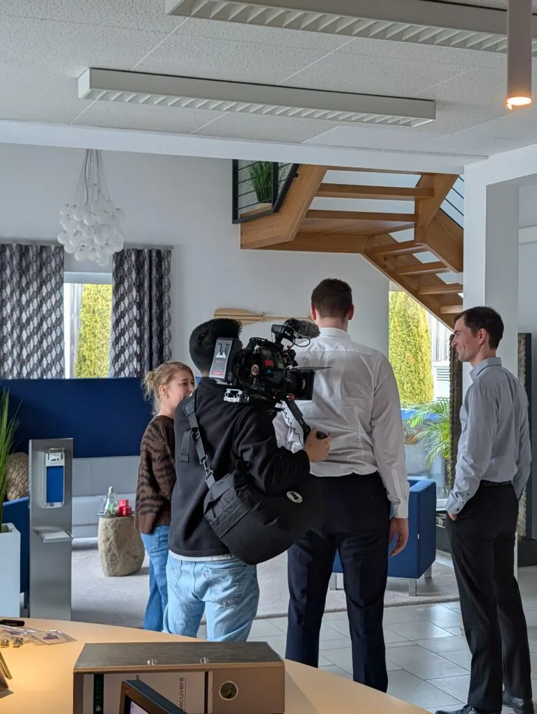 Kameramann des RTL-Teams filmt im Empfangsbereich von secuvera zwei Gesprächspartner