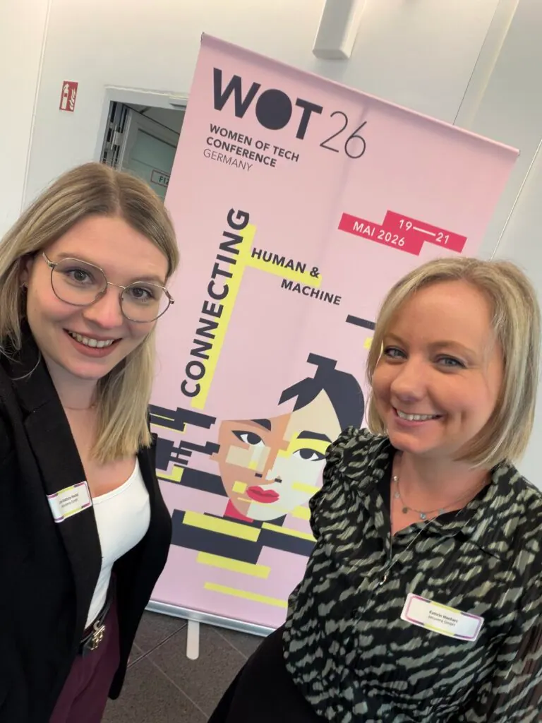 Zwei Mitarbeiterinnen von secuvera vor dem Banner der WOT 26 Women of Tech Conference Germany