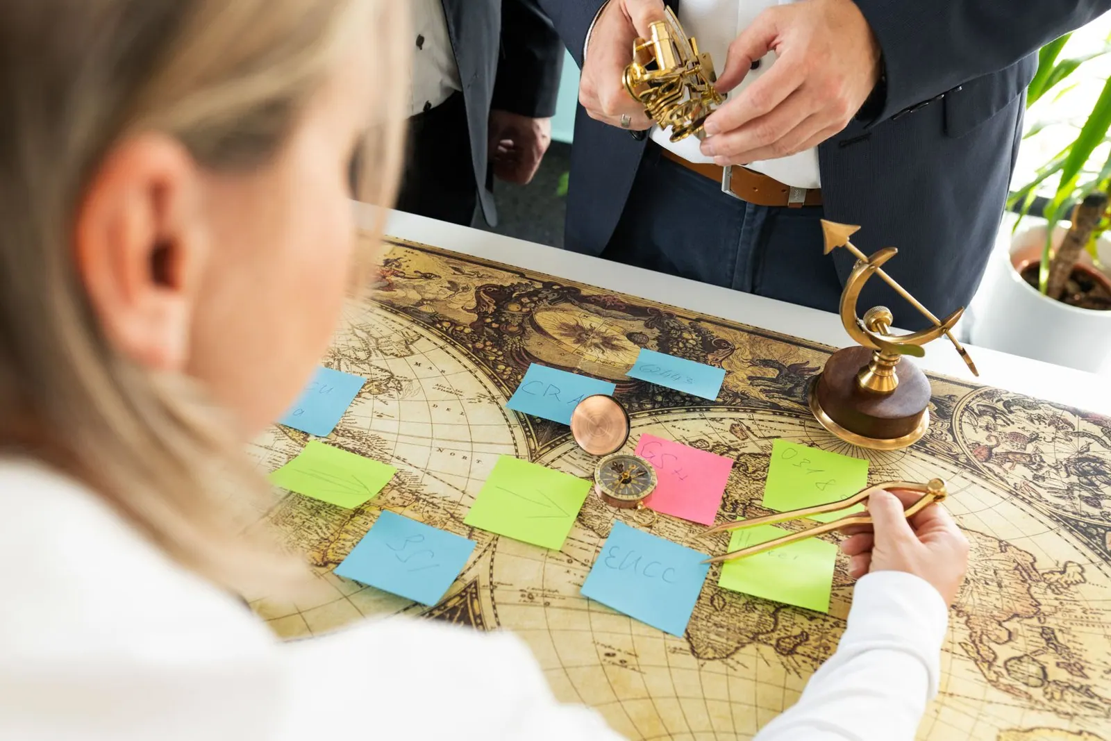 Over-the-shoulder view of a map with sticky notes and navigation instruments