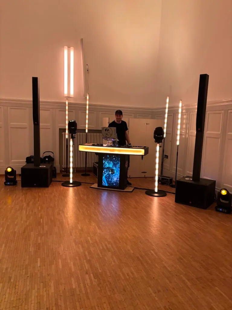 DJ-Pult mit Lautsprechertürmen und Lichtsäulen im Saal der secuvera-Jahresfeier