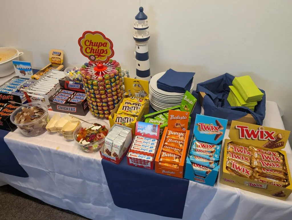 Candybar mit Schokoriegeln, Lollis und Gummibärchen, dazu ein Leuchtturm als Deko, beim Sommerfest 2026