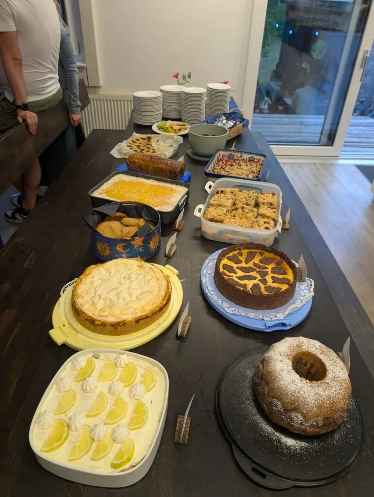 Dessertbuffet mit mehreren selbstgebackenen Kuchen und Torten auf einem langen Tisch
